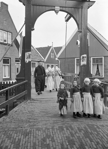 836427 Afbeelding van enkele kinderen in klederdracht bij een bruggetje te Volendam.